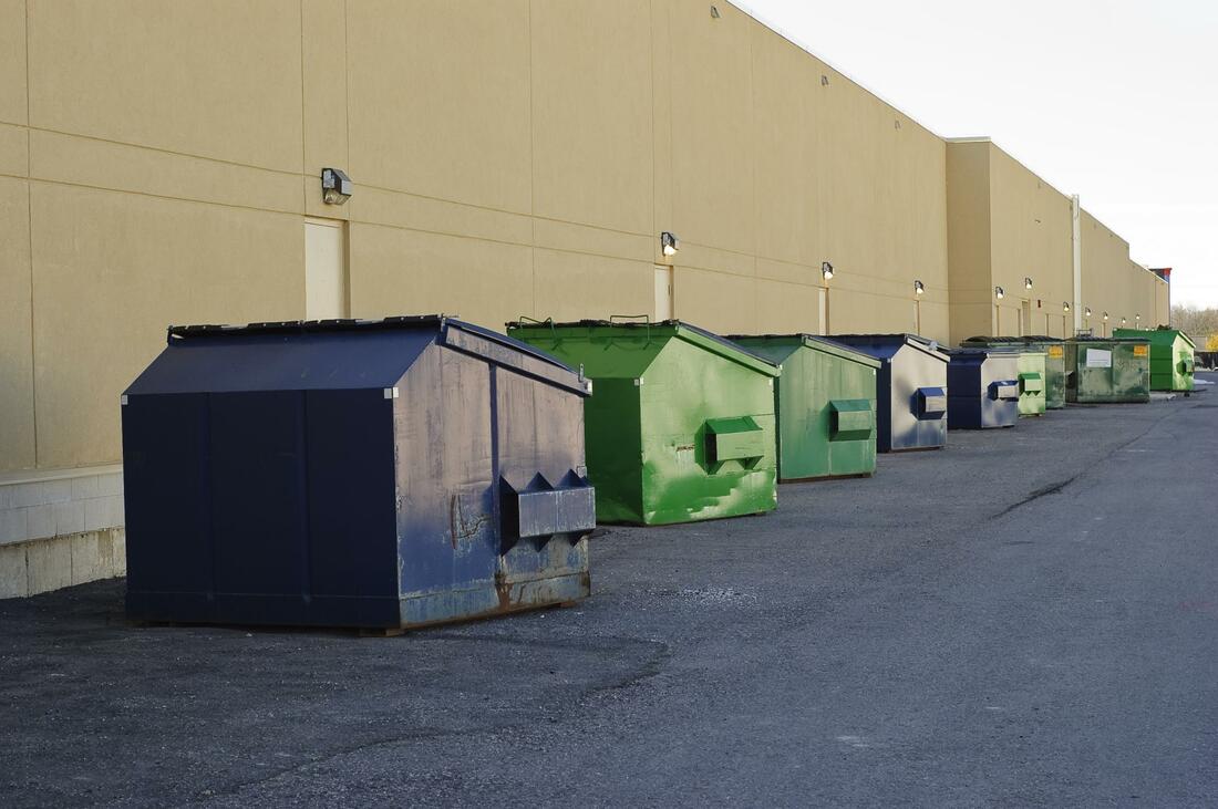 lines of medium sized commercial dumpsters for rent